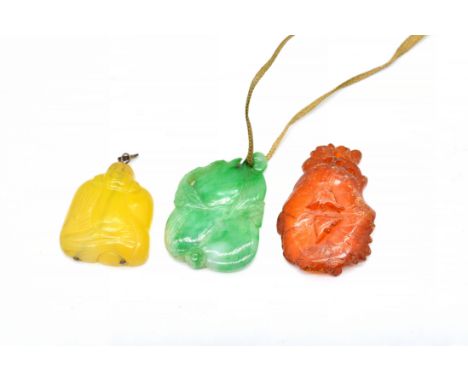 THREE ASIAN PENDANTS (3)Comprising; a jade pendant carved as stylized fruit, a translucent amber pendant, in a floral design 