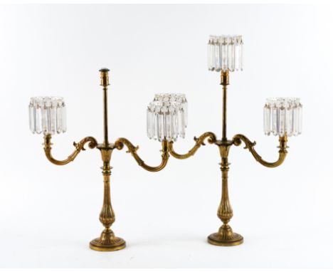 A PAIR OF LATE REGENCY GILT-BRASS AND GLASS THREE-LIGHT CANDELABRA (2)With integral cut-glass petal shaped drip-pans and cand