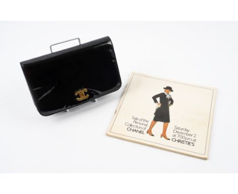 CHANEL: A SMALL BLACK PATENT LEATHER FLAP BAG AND A CHRISTIE'S AUCTION CATALOGUE (2)With authenticity card, in plain black pa