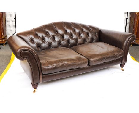 A BROWN LEATHER UPHOLSTERED HUMP BACK SOFA ON TURNED SUPPORTS213cm wide; 86cm highCondition report:&nbsp;Good overall conditi