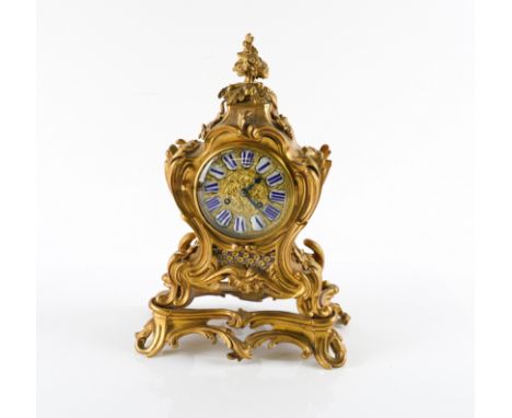 A LOUIS XV STYLE ORMOLU MANTEL CLOCKCirca 1900
The case with scrolling acanthus leaves on integral plinth, enamel Roman chapt