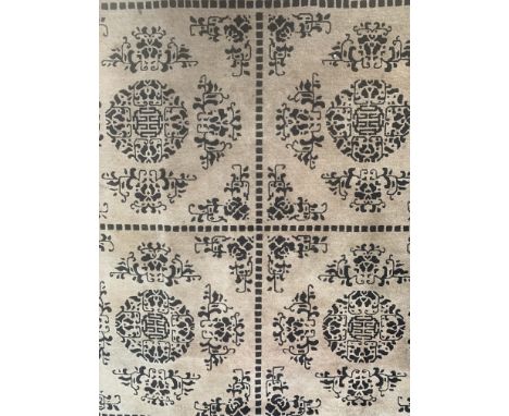 A CHINESE CARPETThe light brown field with eight compartments each with a fretwork roundel and supporting floral sprays in da