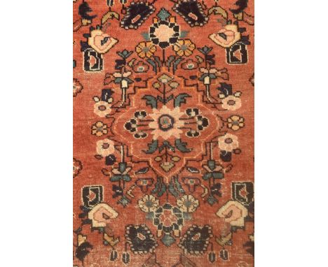 A BIDJAR RUNNERThe madder field with an allover design of floral sprays and two medallions, and indigo rosette and leaf vine 