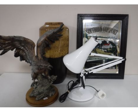 An eagle figure on wooden base, angel poised lamp, West German vase and a Southern Comfort mirror 