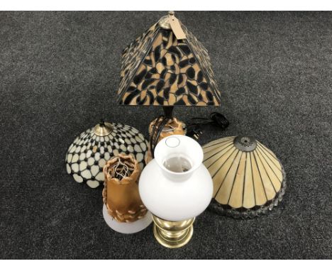 A brass oil lamp with glass chimney and shade, Tiffany style table lamp, two further shades, table lamp etc