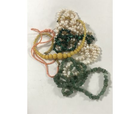 A group of five necklaces to include a large pearl example, jade, coral, malachite etc