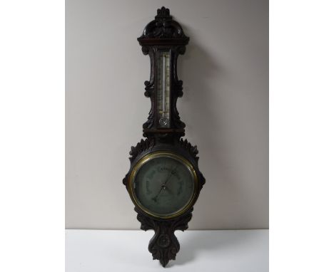 An early 20th century carved oak cased barometer by F. Robson & Co of Newcastle with silvered dial