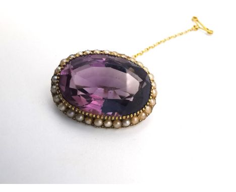 A Victorian yellow metal (tests as 14ct gold) amethyst and seed pearl oval cluster brooch, set with an oval mixed cut amethys