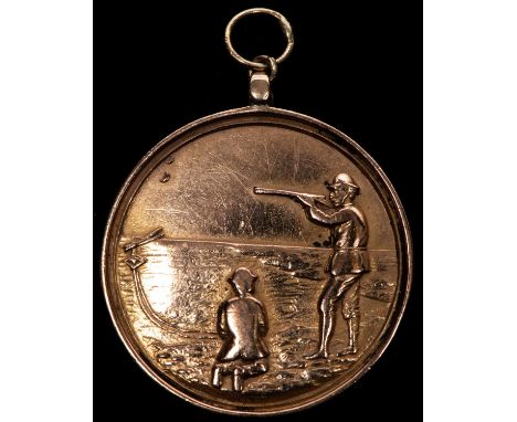 A 9 ct gold shooting award, obverse shooting left with clay pigeon operative kneeling at his feet, design initials "W J D" to