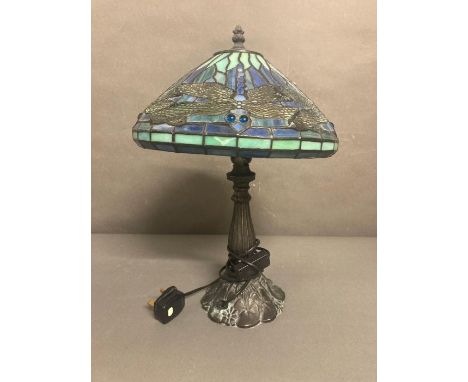 A blue and turquoise stained glass Tiffany style lamp with dragon fly detail 