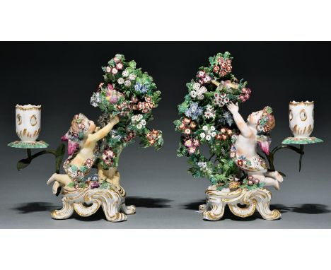 A pair of Bow 'Cupid catching a bird' bocage candlesticks, c1770, 22cm h, red enamel anchor and dagger or unmarked    Old ove