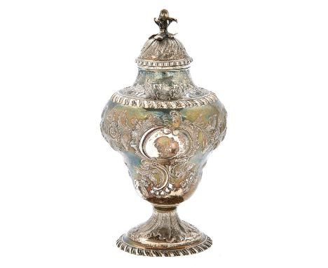 A George III silver tea caddy and cover, of pear shape, crisply chased with an eagle, flowers and rocaille, the domed cover w