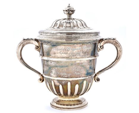 Racing Trophy. A George V silver cup and cover,&nbsp;of urnular form, with ogee domed cover and leaf capped handles, inscribe