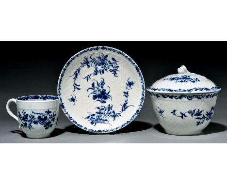 A Worcester feather moulded sugar bowl and cover and coffee cup and saucer, c1765, painted in underglaze blue with the Feathe