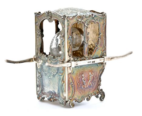 An Edwardian silver sedan chair novelty inkwell, cast with scenes and rocaille, containing silver mounted non-spill glass wel