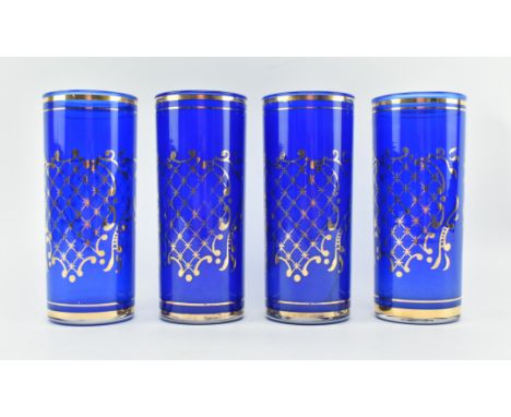 A set of four 20th century cobalt blue &amp; gilt drinking glasses. Each cylindrical glass decorated with gilt ring borders, 