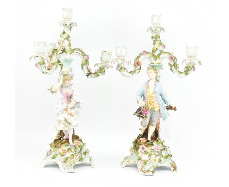 A pair of early 20th century German porcelain three branch candelabras. Each candelabra with three floral branches over centr
