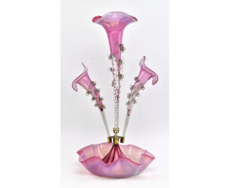 An early 20th century cranberry vaseline glass epergne with stem vases and canes. The centrepiece with central fluted trumpet