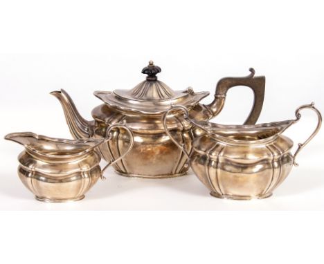 A THREE PIECE SILVER TEA SET  with ribbed decoration and elongated trophy handles, consisting of a bachelors teapot with ebon
