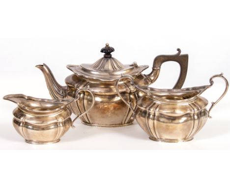 A THREE PIECE SILVER TEA SET  with ribbed decoration and elongated trophy handles, consisting of a bachelors teapot with ebon