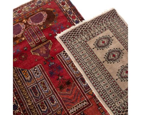 TWO PRAYER MATS  to include a Middle Eastern example on a red ground with repeating motif border and architectural element de