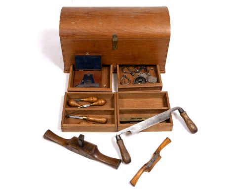 A DOME TOPPED WOODEN CARPENTRY TOOLBOX and tools therein with carved wooden handles and a compartmented fitted interior, 52cm