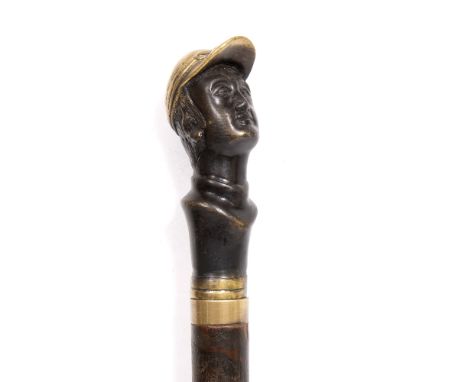 A WALKING CANE  with bronze finial cast in the form of a head of a jockey 92cm long overall 