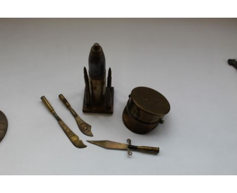 Trench art made into three rifle bullet butter knives, 1917 shell case made into peaked cap, small artillery lighter with 303