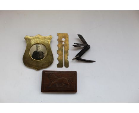 Trench art brass picture frame with photo of WWII soldier, brass buckle polish guard, military jack knife, wooden cigarette b