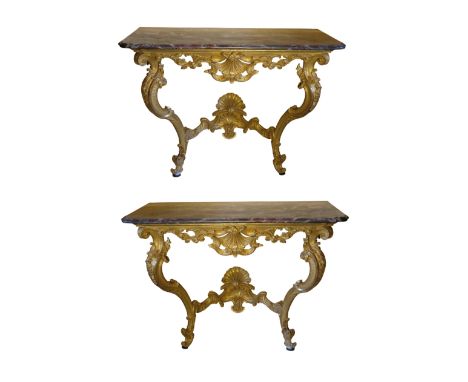 A PAIR OF GILTWOOD CONSOLE TABLES 18th century, probably North Italian, with pierced "C"-scroll and shell-carved frieze, on d