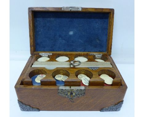 An oak gaming box with playing cards and poker chips, width 23.5cm