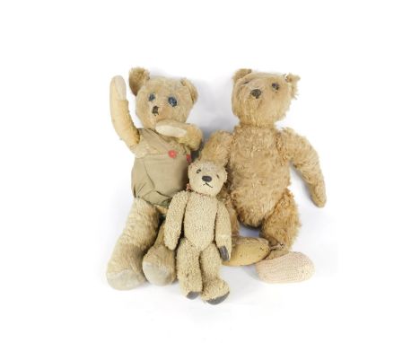 An early 20thC long snouted straw filled teddy bear, 50cm long, teddy bear with button eyes, 53cm long, and a further teddy b