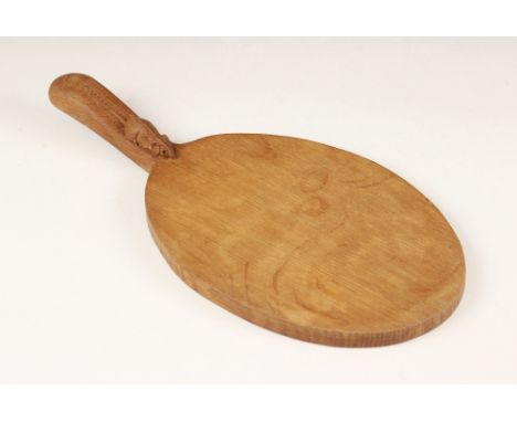 Workshop of Robert "Mouseman" Thompson of Kilburn, a carved oak cheese board, of oval form, the signature mouse carved to the