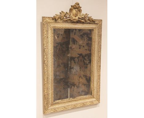 A George III gilt wood and gesso wall mirror, the speckled mirrored plate within a frame moulded with simulated lattice wicke
