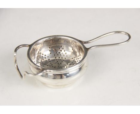 A George V silver tea strainer and stand, W J Myatt & Co, Birmingham 1933, the circular bowl with pierced detail, wirework ha