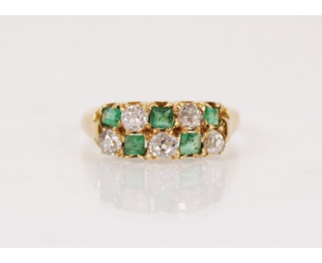 A Victorian emerald and diamond 18ct gold ring, comprising two rows of alternating step cut emeralds and old cut diamonds, he