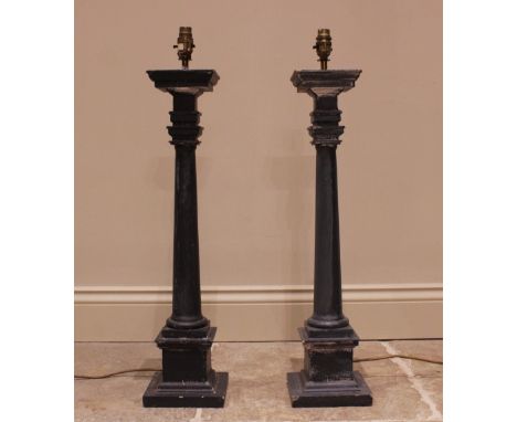 A pair of painted wooden column candlesticks, each of tapering cylindrical form, upon an integrated plinth base, 66cm high (2