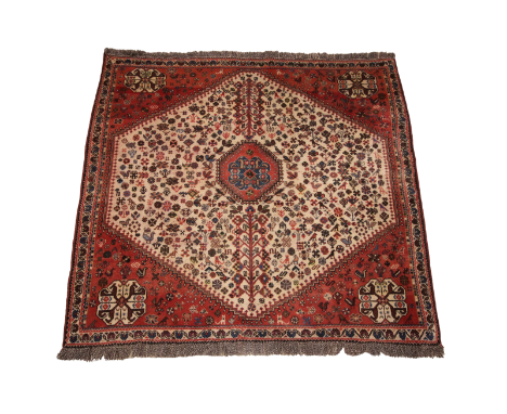 A hand-woven Caucasian wool carpet in red and ivory colour ways, the central hexagonal field with foliate and zoomorphic moti