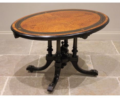 A Victorian birds eye maple and ebonised Aesthetic Movement loo table, the quarter veneered oval tilt top, raised upon four g