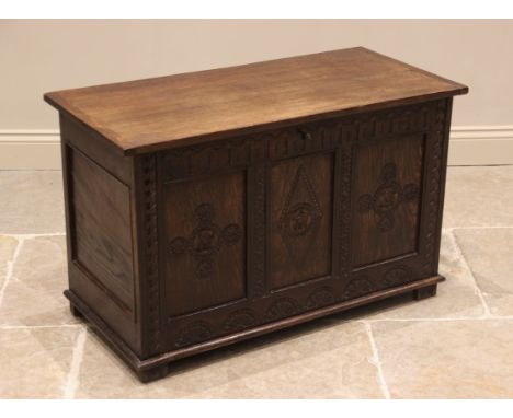 A 17th century style oak coffer, the cleated plank top above three panels carved with geometric Celtic motifs over a lower lu