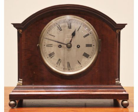 An early 20th century mahogany cased mantel clock, by Russells Ltd, Manchester, the arched case with quarter pilasters and in