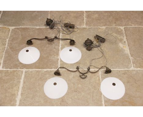 A pair of Edwardian brass rise and fall ceiling lights, each with twin branches extending to opaline glass conical shaped sha