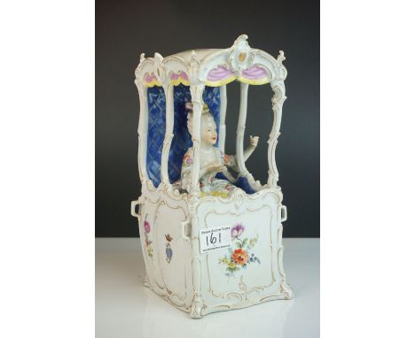 A continental ceramic sudan chair with seated lady to interior  decorated with floral sprays. 