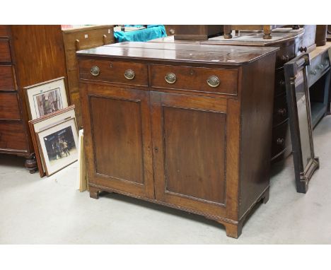 Early 19th century Mahogany Cupboard / Sideboard, the Two Drawers with oval brass handles, over two cupboard doors, raised on