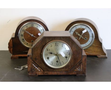 Three oak cased mid 20th century mantel clocks together with one clock key 