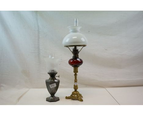 An early 20th century pewter oil lamp with engraved decoration, floral patterned shade and glass chimney together with a bras