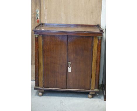 William IV Mahogany Cabinet, the top with gallery rail, over two panel doors flanked by brass capped plain column supports, o