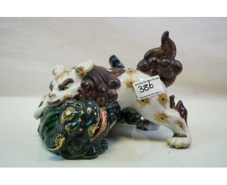 A ceramic Japanese figure of two lions fighting. 