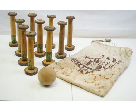 A vintage set of wooden skittles and ball in a fabric bag titled The Bobbin Skittle kit. 