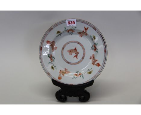 A Chinese Woucai 'gold fish' dish, probably Kangxi, 22cm diameter, on carved hardwood plate stand. Condition Report: Appears 